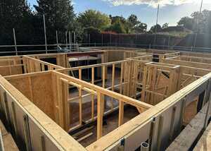 Framing structure of a building under construction on a sunny day.